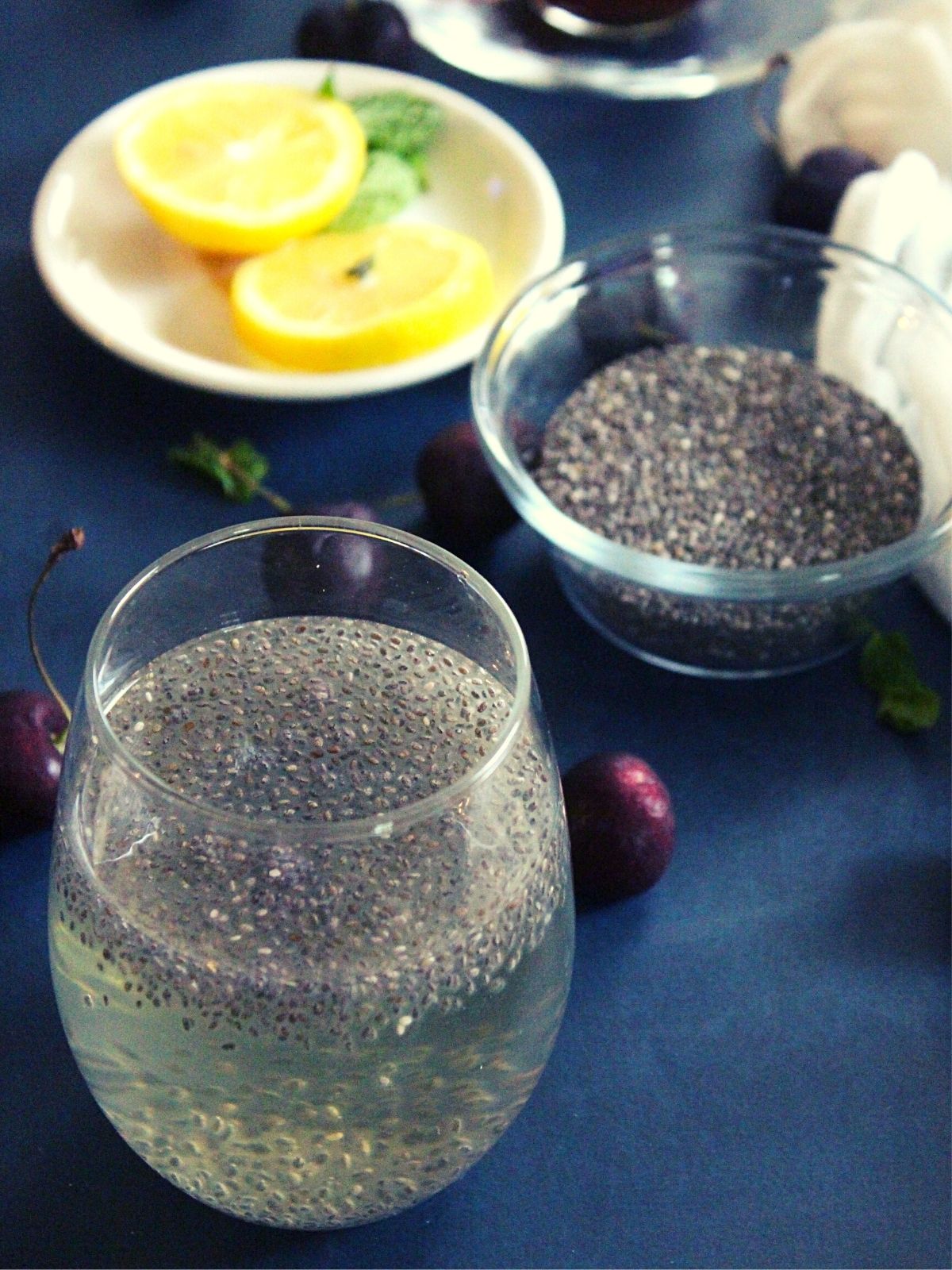 chia seeds drink for weight loss served in a glass with lemon slices and chia seeds beside