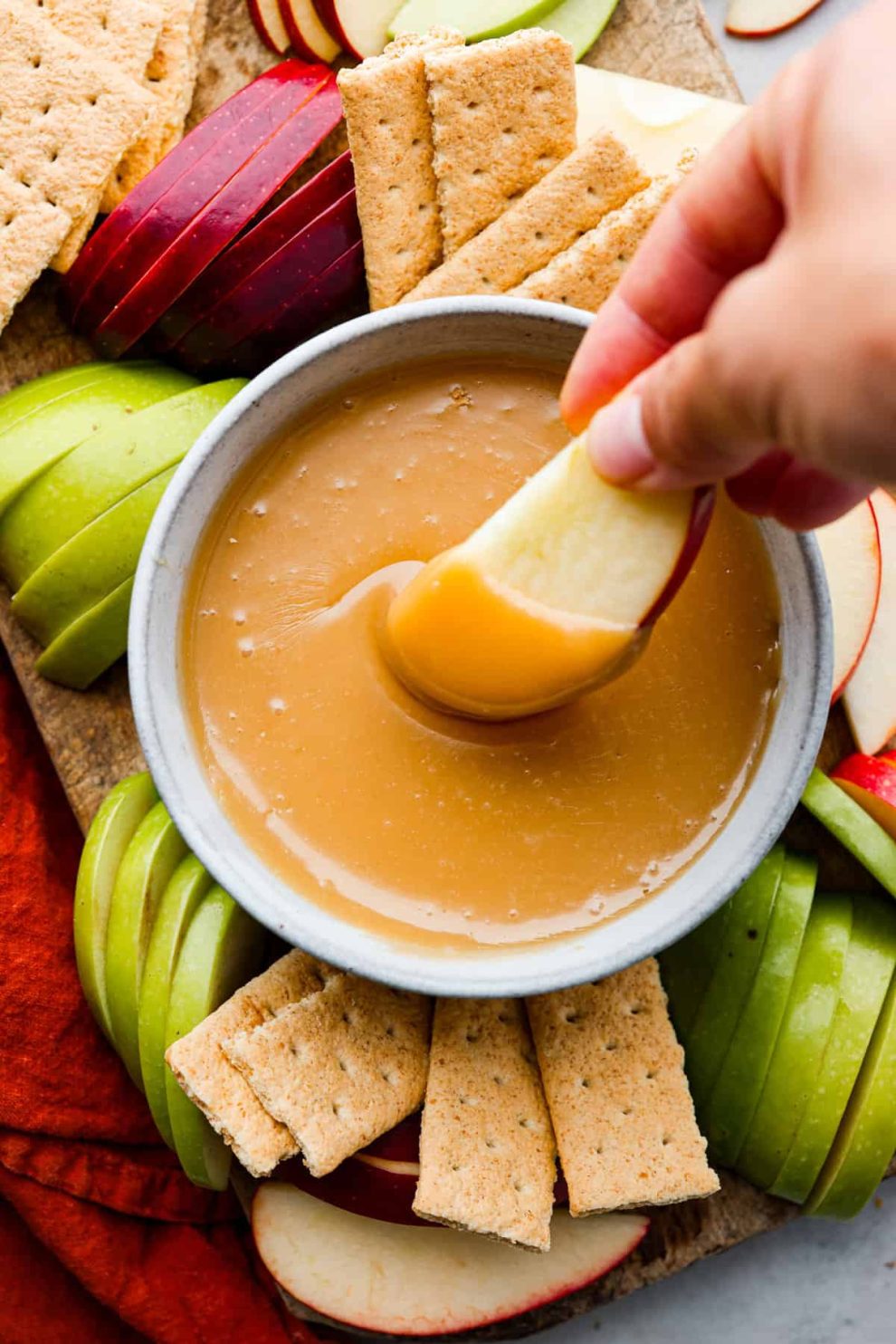 Hero image of an apple slice being dipped in caramel.