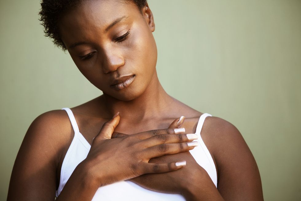 African woman with hands crossed over heart