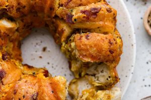 Overhead shot of savory breakfast monkey bread with piece pulled out.