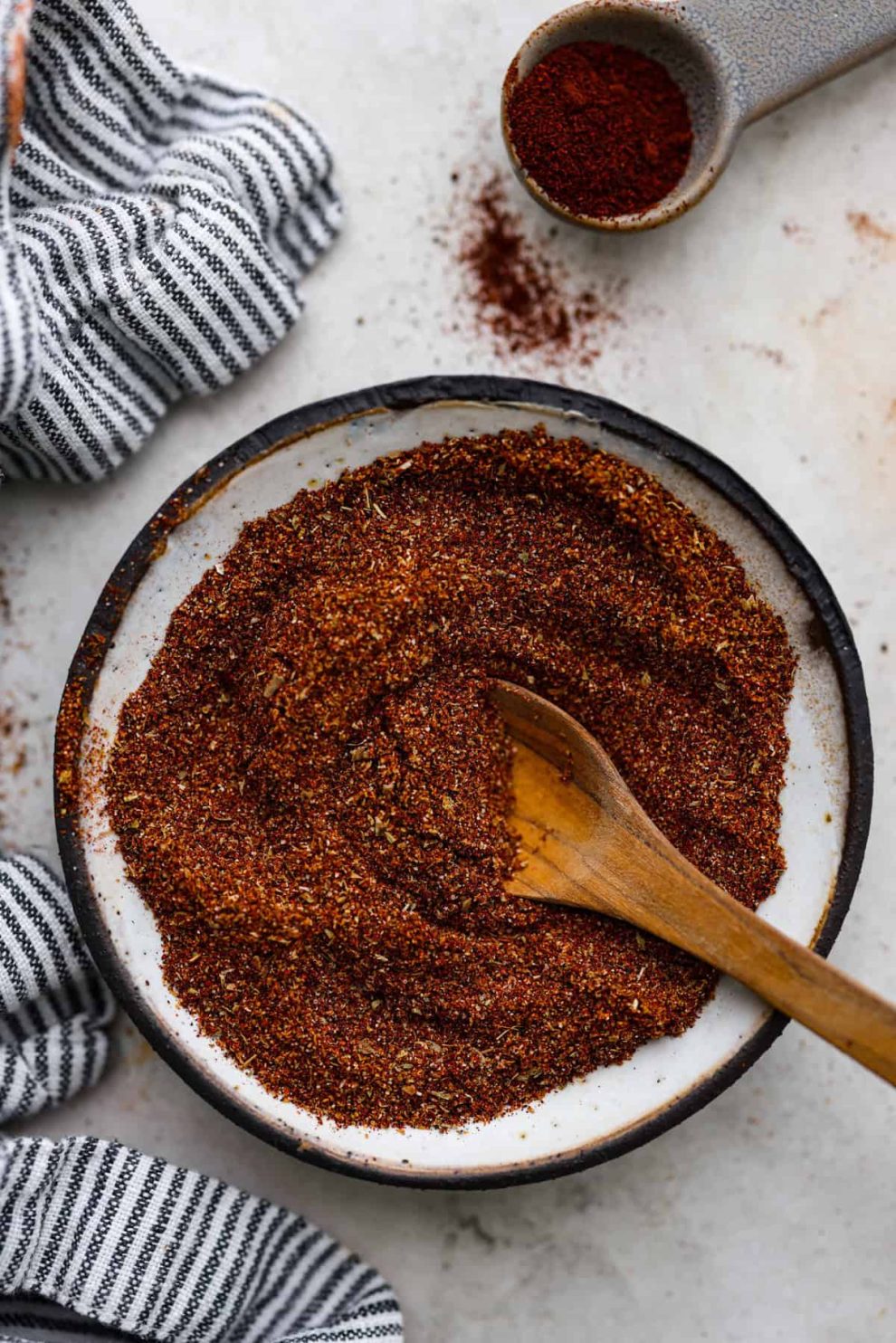 Overhead shot of mixed chipotle seasoning in a bowl with wooden spoon sticking out of it.