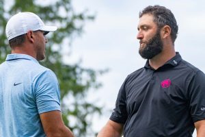 Captain Brooks Koepka, left, of Smash GC, shakes hands with captain Jon Rahm, of Legion XIII, on the 18th green during the final round of LIV Golf Greenbrier at The Old White at The Greenbrier, Sunday, Aug.  18, 2024, in White Sulphur Springs, W.Va. (Mike Stobe/LIV Golf via AP)