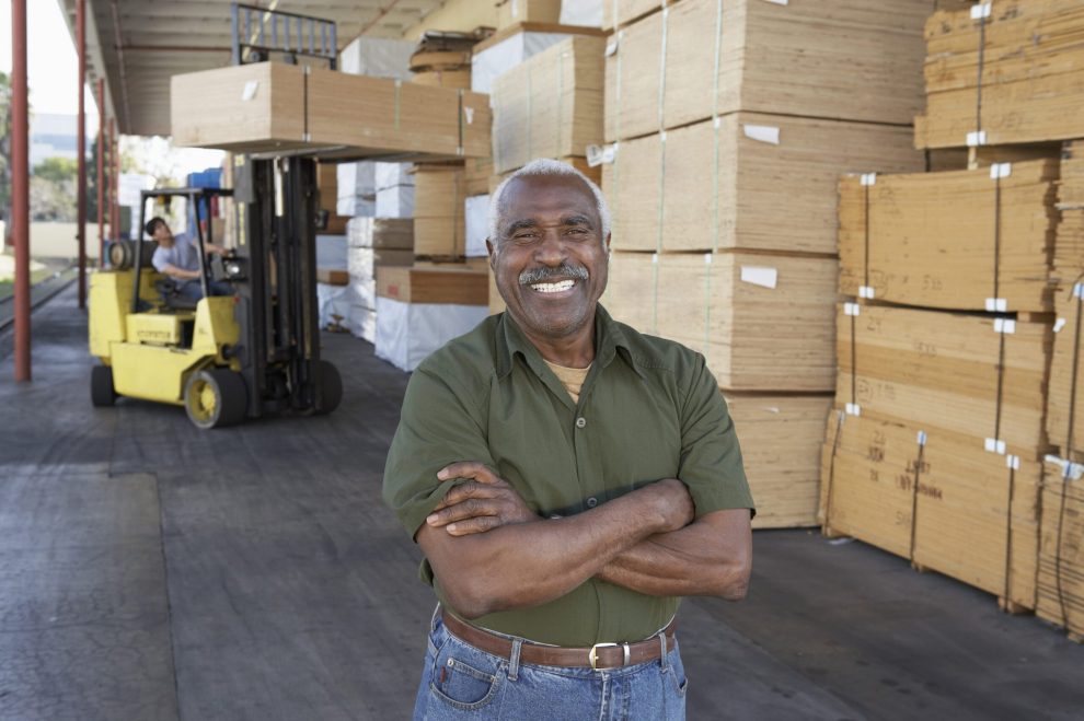 Senior worker in front of forklift