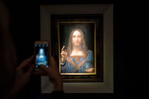 NEW YORK, NY - NOVEMBER 15: A visitor takes a photo of the painting 'Salvator Mundi' by Leonardo da Vinci at Christie's New York Auction House, November 15, 2017 in New York City. The coveted painting is set to be auctioned off on Wednesday night and has been guaranteed to sell for over $100 million.(Drew Angerer/Getty Images)