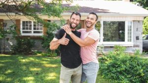 Happy couple in the front yard of their new house