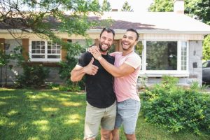 Happy couple in the front yard of their new house