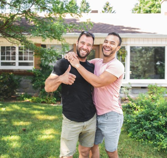 Happy couple in the front yard of their new house