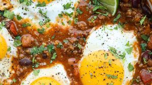 Overhead shot of a pot of breakfast chili with fried eggs on top.