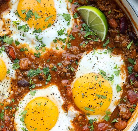 Overhead shot of a pot of breakfast chili with fried eggs on top.