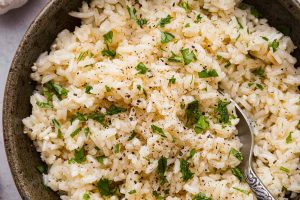 Overhead shot of a bowl of garlic butter rice with a spoon in it.