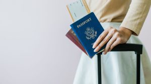 Woman with luggage, boarding pass, and two passports