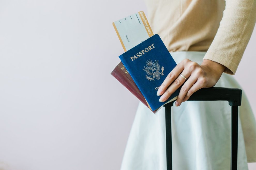 Woman with luggage, boarding pass, and two passports