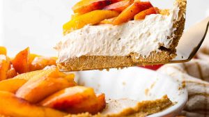 Side shot of a slice of fresh peach pie being lifted out of the pie pan.