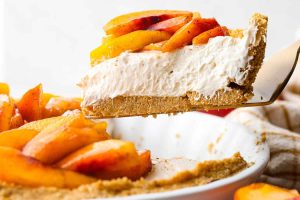 Side shot of a slice of fresh peach pie being lifted out of the pie pan.