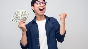 Happy man holding money with his fist up