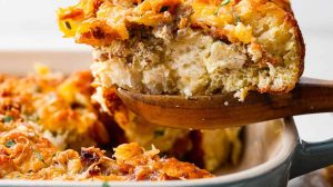 Side shot of a serving of bubble up breakfast casserole being taken out of the baking dish.