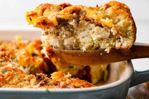 Side shot of a serving of bubble up breakfast casserole being taken out of the baking dish.