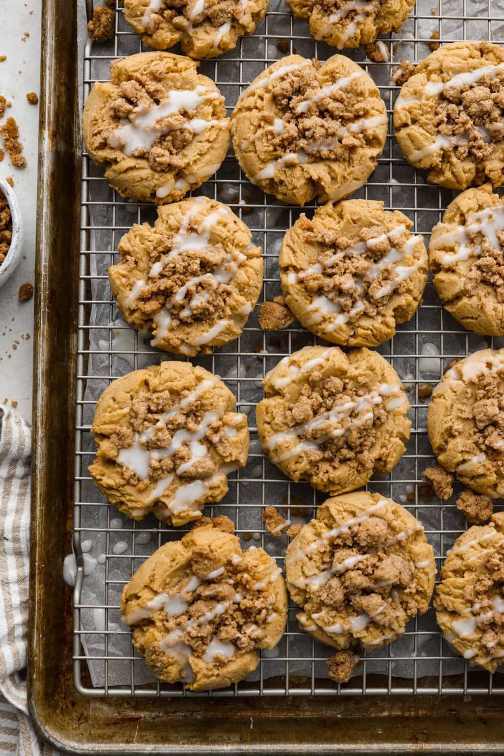 Overhead shot of coffee cake cookies on a cooling rack over a baking sheet.