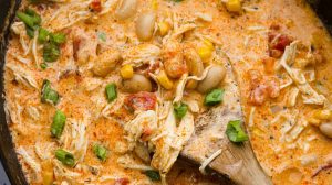 Overhead shot of crockpot buffalo chicken chili with a wooden spoon.