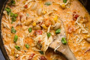 Overhead shot of crockpot buffalo chicken chili with a wooden spoon.