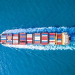 Cargo ship sails on a blue sea.