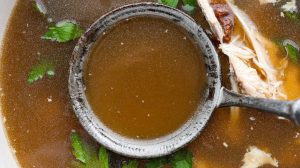 Overhead shot of bone growth in a pot with a ladle.