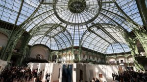 A huge glass-covered roof over exhibitors at a trade fair.