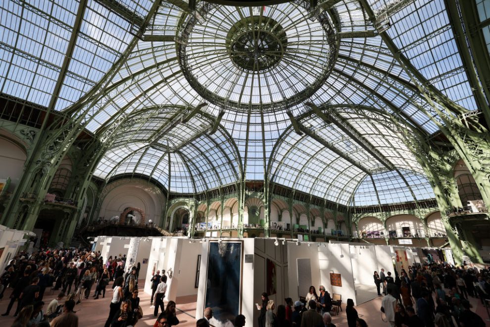 A huge glass-covered roof over exhibitors at a trade fair.